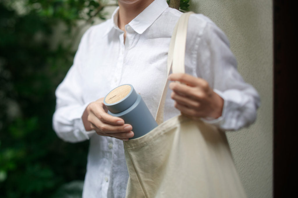 Rivers MOKU 500 drink bottle held in hand, showing scale and wood grain